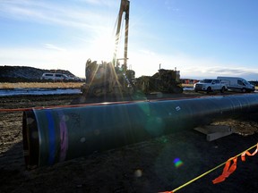 In this Dec. 3, 2019 file photo, construction workers can be seen at the site of a the Trans Mountain oil pipeline in Acheson, Alta.