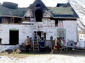 Officials remove debris and a child's toy from the scene of a fatal house fire near Westport on Wednesday afternoon.