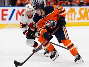 Kailer Yamamoto #56 of the Edmonton Oilers battles against Erik Brannstrom #26 of the Ottawa Senators during the second period at Rogers Place on January 15, 2022 in Edmonton, Canada.