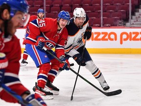 Edmonton Oilers' Cody Ceci and Montreal Canadiens' Laurent Dauphin battle for the puck, Jan. 29, 2022.