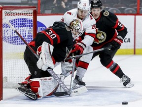 Senators goaltender Matt Murray (30) stops Carolina Hurricanes center Sebastian Aho (20) as Ottawa Senators defenceman Lassi Thomson (60) checks during second period on Thursday night.