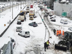 A Greek Army bulldozer plows snow next to abandoned vehicles, following heavy snowfall in Athens January 25, 2022.