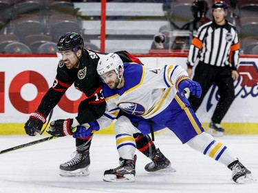 Ottawa Senators left wing Zach Sanford (13) and Buffalo Sabres defenceman Will Butcher (4) battle during the third period.
