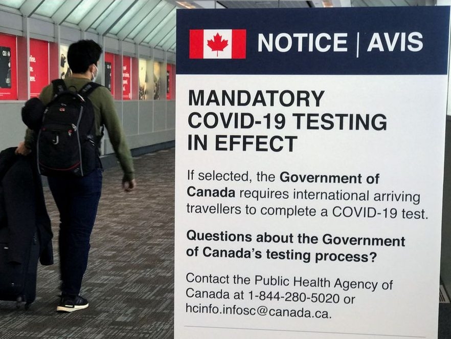 A traveller walks past a "Mandatory COVID-19 Testing" sign at Pearson International Airport during the COVID-19 pandemic in Toronto, Dec. 18, 2021.