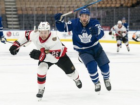 Ottawa Senators defenceman Erik Brannstrom (26) and Toronto Maple Leafs left wing Michael Bunting (58) chase down the puck during the third period at Scotiabank Arena, Jan. 1, 2022.