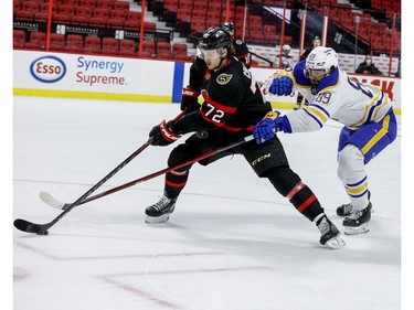 Ottawa Senators defenceman Thomas Chabot maintains possession of the puck as Buffalo Sabres right wing Alex Tuch (89) reaches for it.