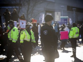 Files: Ottawa police watch as a counter protest took place on the front lawn of City Hall and Convoy protestors faced off from Confederation Park.
