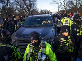 Counter protesters turned the tables on a "Freedom Convoy" on Riverside Drive at Bank Street, Sunday, Feb. 13, 2022, stopping about 25 vehicles and holding up their convoy on day 17 of the protest in Ottawa. Once vehicle drivers met the demands of removing all decals and flags from their vehicles they were escorted out of the area by police escort.