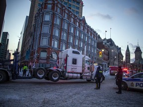 Police from different forces across the country joined together to try to bring the "Freedom Convoy" occupation to an end Saturday, February 19, 2022. Tow trucks with police labeling on the working vehicles towed out RV's and trucks from Wellington Street Saturday night along Elgin Street.