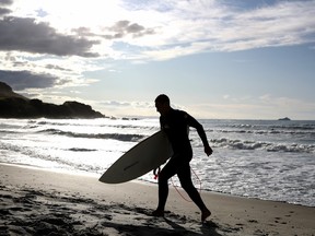 Surfers enjoy the waves at Mount Maunganui in Tauranga, New Zealand.