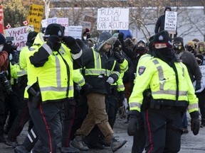 Counter protestors of the anti vaccine mandate protests continuing in downtown Ottawa. Ottawa police remove a anti mandate protester from amongst the counter protest crowd. Saturday, Feb. 5, 2022