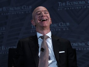 Jeff Bezos laughs as he participates in a discussion during a Milestone Celebration dinner Sept. 13, 2018 in Washington, D.C.
