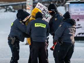 A demonstrator is arrested by police in Ottawa on February 18, 2022, as they begin to remove protesters demanding an end to Covid-19 mandates.