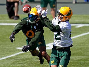 Defensive back Jonathan Rose (left) and receiver Greg Ellingson (right) reach for the ball during the Edmonton Elks training camp at Commonwealth Stadium in Edmonton on Monday July 12, 2021.