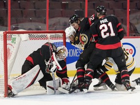 Senators goalie Matt Murray covers the puck in front of Bruins forwards Taylor Hall (71) and Erik Haula (56) in the first period.