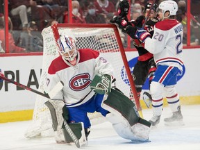 Montreal Canadiens goalie Andrew Hammond (37) makes a save as Ottawa Senators right wing Tyler Ennis (63) is driven into the net by Montreal defenceman Chris Wideman (20) in the second period at the Canadian Tire Centre, Saturday, Feb. 26, 2022.