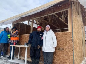 Bertrand Brunet and Tina Trealout stand outside the makeshift wooden "community kitchen" near Confederation Park.