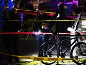 A police officer views the crime scene, where according to the Portland Police Bureau one person was shot dead and five others were wounded, at Normandale Park in Portland, Oregon, U.S., February 19, 2022.