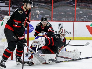 Ottawa Senators goaltender Matt Murray (30) makes a save as defencemen Erik Brannstrom (26) and Josh Brown defend during the second period.