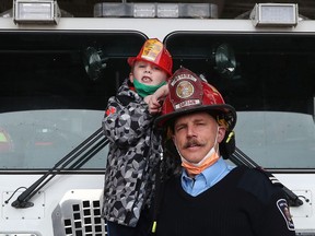 OTTAWA - Feb 10, 2022 - Cody McNeil poses for a photo with Captain Steve Styles at the Ottawa Fire Station in Stittsville Thursday. Five years ago this month, little Cody, only a year old, was badly burned in a fire in his crib in Kanata.