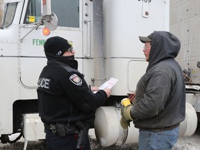 A trucker gets three tickets from the Ottawa police on Elgin Street in Ottawa on Sunday.