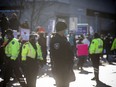 Ottawa Police Service members accompany Ottawa Bylaw officers as they issue parking tickets and fines during the convoy protest in the city's downtown core.