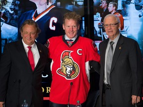 Daniel Alfredsson, (C), with Eugene Melnyk (L) and Bryan Murray, (R), after donning the jersey he wore on the last day of his season during the press conference where the former Ottawa Senators captain signed a one day contract enabling him to retire as an Ottawa Senator.