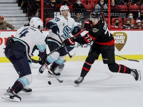 Ottawa Senators defenceman Thomas Chabot (72) shoots between Seattle Kraken defenseman Haydn Fleury (4) and defenceman Vince Dunn (29) during first period NHL action at the Canadian Tire Centre on March 10, 2022.