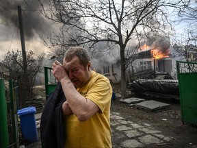 Yevghen Zbormyrsky, 49, reacts in front of his burning home after it was hit by a shelled in the city of Irpin, outside Kyiv, on March 4, 2022.