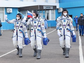 International Space Station (ISS) crew members Russian cosmonauts Oleg Artemyev, Denis Matveev and Sergey Korsakov walk before departing for boarding the Soyuz MS-21 spacecraft for the launch at the Baikonur Cosmodrome, Kazakhstan March 18, 2022.