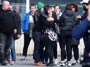 People gather near a gymnasium where witnesses and relatives of victims are received near the site where a car crashed into a crowd of early morning carnival-goers killing four people and injuring 12 people seriously in Strepy-Bracquegnies, on March 20, 2022. - "A car driving at high speed ran into the crowd that had gathered to attend (the carnival)," La Louviere mayor Jacques Gobert told Belga news agency.