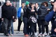 People gather near a gymnasium where witnesses and relatives of victims are received near the site where a car crashed into a crowd of early morning carnival-goers killing four people and injuring 12 people seriously in Strepy-Bracquegnies, on March 20, 2022. - "A car driving at high speed ran into the crowd that had gathered to attend (the carnival)," La Louviere mayor Jacques Gobert told Belga news agency.