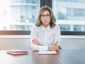 Corporate woman sitting alone at table in conference room.