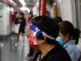 A woman wears a face mask and shield in an MTR train, amid the coronavirus disease (COVID-19) pandemic in Hong Kong, China, March 7, 2022.