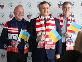 Jeff Hunt (left), President and Strategic Partner of Atlético Ottawa, Andrii Bukvych, Chargé d’Affaires at the Ukrainian Embassy (centre) and Ottawa mayor Jim Watson (right) announce an initiative in support of humanitarian aid for Ukraine in Ottawa on March 28, 2022.