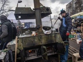 Volunteers make food to feed soldiers and civilians at a roadside camp close to the north eastern frontline on March 9, 2022 in Kyiv.
