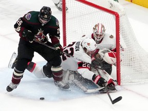 Senators goaltender Matt Murray (30) makes a save, but then gets hit by defenceman Nikita Zaitsev after a collision with Coyotes left-winger Antoine Roussel during the third period.