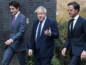 Prime Minister Justin Trudeau (L) walks with British Prime Minister Boris Johnson (C) and Netherlands Prime Minister Mark Rutte (R) in London, England, on March 7, 2022.