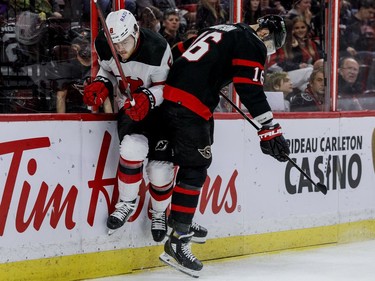 Ottawa Senators left-winger Austin Watson (16) checks New Jersey Devils defenceman Reilly Walsh (8) in the first period at the Canadian Tire Centre on April 26, 2022.