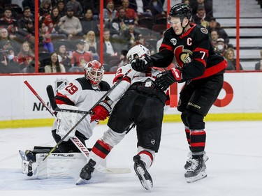 Ottawa Senators left wing Brady Tkachuk (7) battles with New Jersey Devils defenceman Ryan Graves (33) in front of goaltender Mackenzie Blackwood (29) in the first period at the Canadian Tire Centre on April 26, 2022.