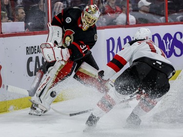Ottawa Senators goaltender Anton Forsberg (31) clears the puck past New Jersey Devils left wing Andreas Johnsson (11) in the second period on Tuesday night at the Canadian Tire Centre.