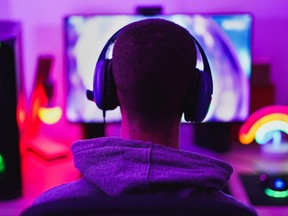 Young man wearing headset and play computer video games online.