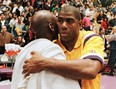 Los Angeles Lakers Earvin "Magic" Johnson (R) hugs Michael Jorden of the Chicago Bulls 02 February after their game at the Great Western Forum in Inglewood, California.