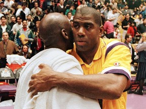 Los Angeles Lakers Earvin "Magic" Johnson (R) hugs Michael Jorden of the Chicago Bulls 02 February after their game at the Great Western Forum in Inglewood, California.