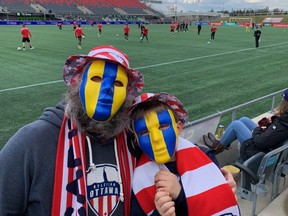 Bryce Crossman (dad) and Nelson Crossman, show off their Ukraine inspired masks for the Atletico Ottawa game on Saturday.