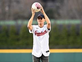 Tom Hanks holds his co-star Wilson before throwing out the ceremonial first pitch prior to Cleveland Guardians' home opener against the San Francisco Giants at Progressive Field.
