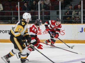 Luca Pinelli (20) of the 67's keeps an eye on teammate Vinzenz Rohrer and Jan Mysak of the Bulldogs as he skates with the puck during Friday's game.