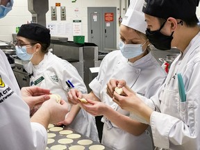 Ukrainian-born pastry chef Elina Olefirenko (second from right), colleagues and students make perogies at Algonquin College as part of Tuesday's fundraiser.