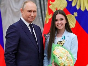 Russian President Vladimir Putin poses for a picture with figure skater Kamila Valieva during an awarding ceremony honouring the country's Olympians at the Kremlin in Moscow, Russia April 26, 2022.