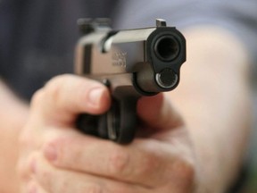 File photo of a man holding a Colt .45 semi-automatic pistol.